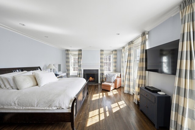 333 E 68th Street Penthouse, New York City, NY 10065 - bedroom with crown molding, dark wood-type flooring, and a warm lit fireplace