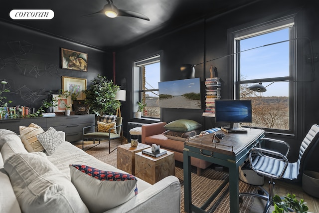 interior space with radiator heating unit, a wealth of natural light, ceiling fan, and visible vents