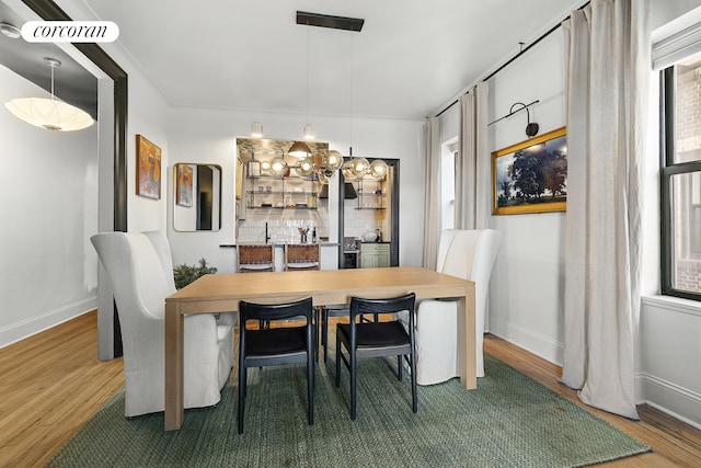 dining area featuring baseboards, wood finished floors, and a healthy amount of sunlight