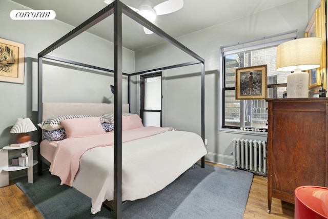 bedroom featuring radiator, wood finished floors, and visible vents