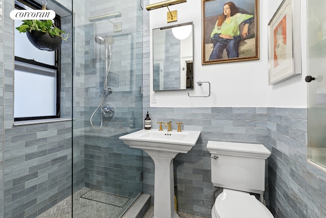 full bath with tile walls, toilet, a wainscoted wall, and a tile shower