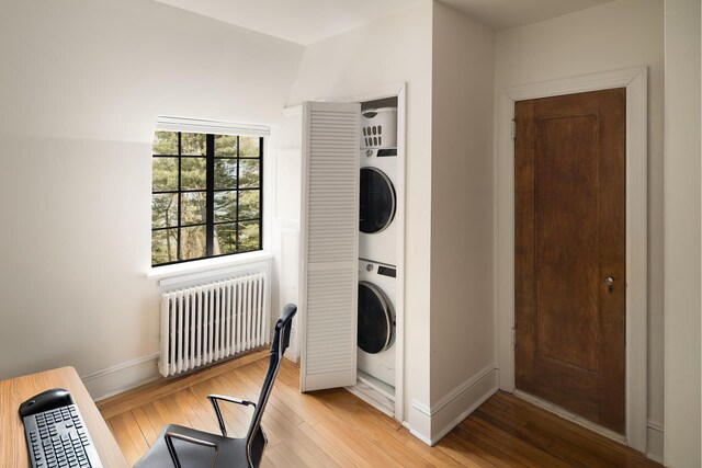 2501 Palisade Ave Unit H2, New York City, NY 10463 - clothes washing area with radiator, stacked washer / dryer, baseboards, and light wood finished floors