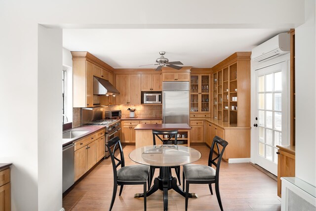 2501 Palisade Ave Unit H2, New York City, NY 10463 - kitchen featuring built in appliances, an AC wall unit, under cabinet range hood, a sink, and a ceiling fan