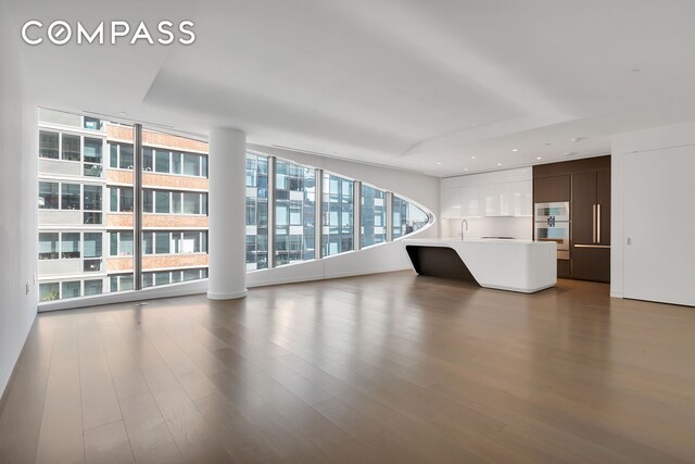 520 W 28th St Unit 18, New York City, NY 10001 - unfurnished living room with expansive windows and wood finished floors