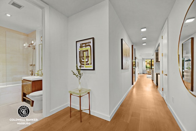 212 E 95th St Unit 2Ab, New York City, NY 10128 - corridor with light wood finished floors, baseboards, and a sink