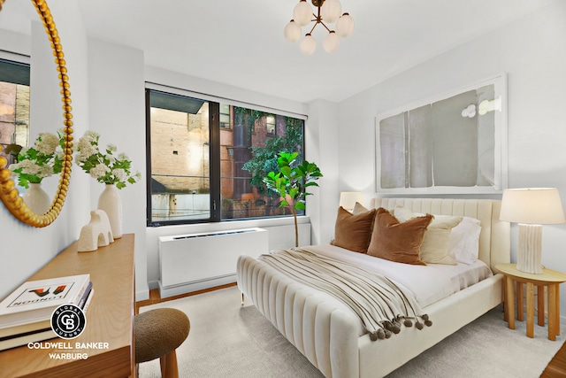 212 E 95th St Unit 2Ab, New York City, NY 10128 - bedroom with radiator, wood finished floors, and a chandelier