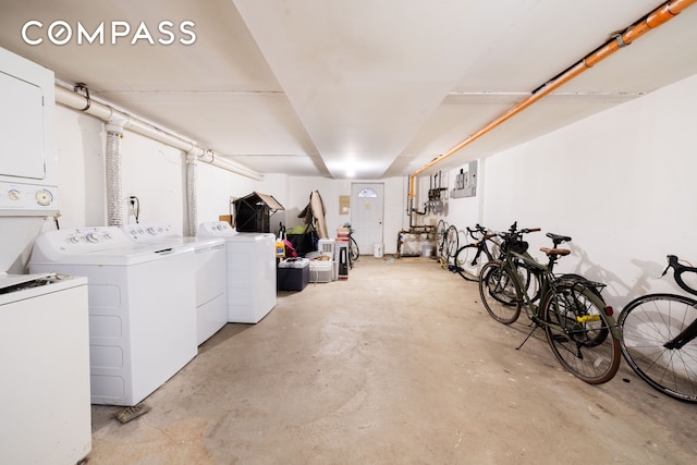 unfinished basement with stacked washer / drying machine and washing machine and clothes dryer