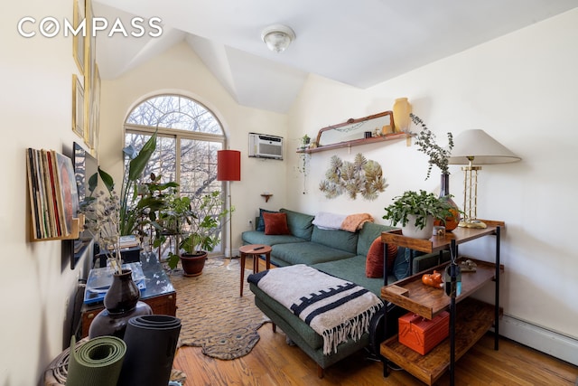 living room featuring a wall mounted AC, vaulted ceiling, baseboard heating, and wood finished floors