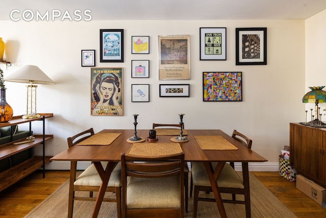 dining space featuring baseboards and wood finished floors