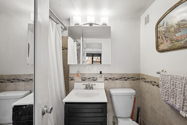 230 E 15th St Unit 3N, New York City, NY 10003 - bathroom featuring tile walls, toilet, vanity, wainscoting, and a shower with curtain