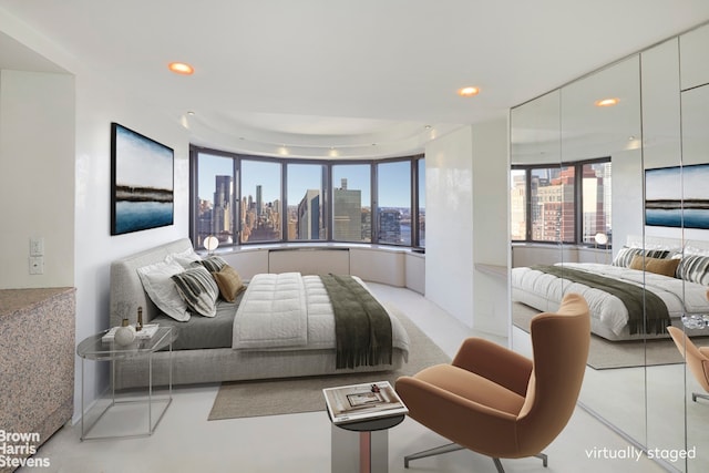 330 E 38th St Unit 51Ef, New York City, NY 10016 - bedroom featuring a view of skyline, multiple windows, and recessed lighting