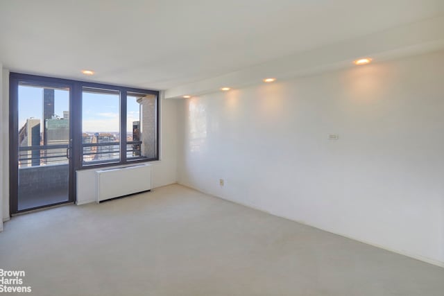 330 E 38th St Unit 51Ef, New York City, NY 10016 - spare room featuring radiator, light colored carpet, and recessed lighting
