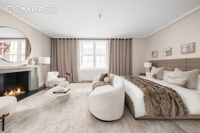 bedroom featuring ornamental molding, multiple windows, and a warm lit fireplace