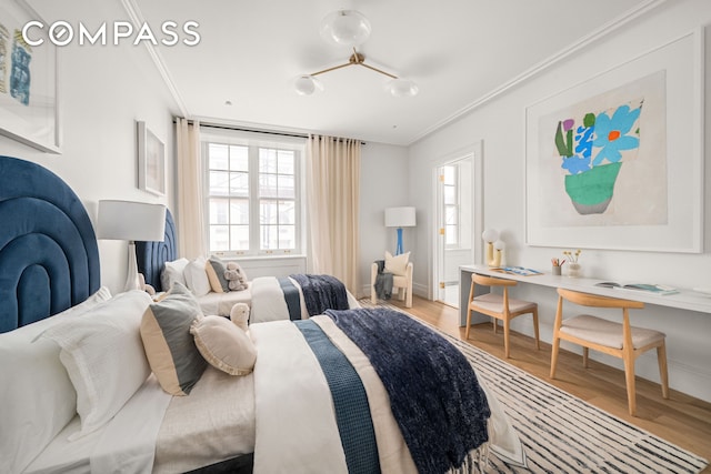 bedroom with ornamental molding, multiple windows, light wood-style floors, and baseboards