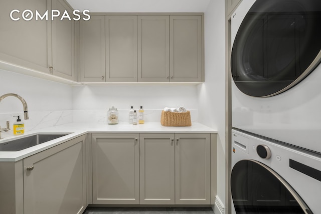 washroom with stacked washer / dryer and cabinet space