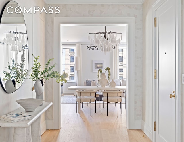 dining area featuring light wood-style flooring, a chandelier, baseboards, wallpapered walls, and ornamental molding