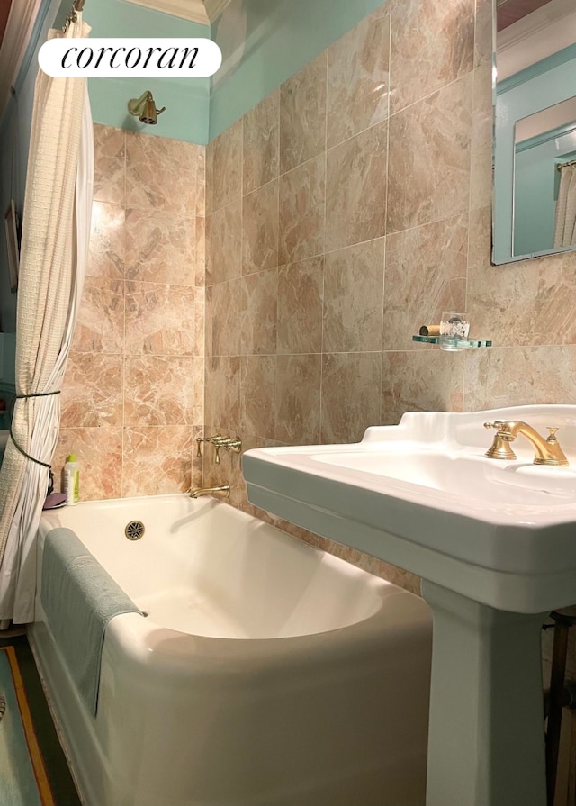 444 E 57th St Unit 5C, New York City, NY 10022 - full bathroom featuring tile walls, shower / bath combo with shower curtain, and a sink