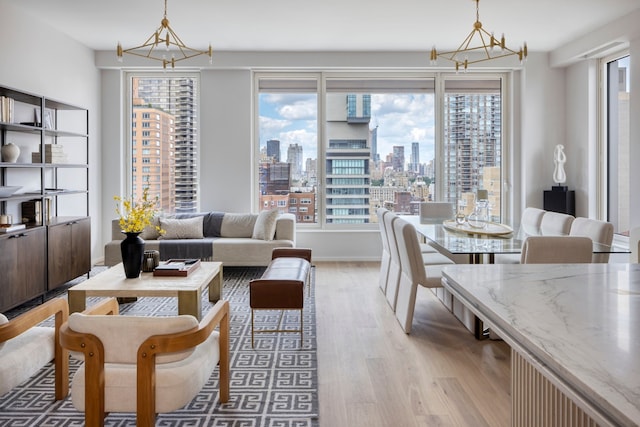dining room featuring light wood-type flooring, a chandelier, healthy amount of natural light, and a view of skyline