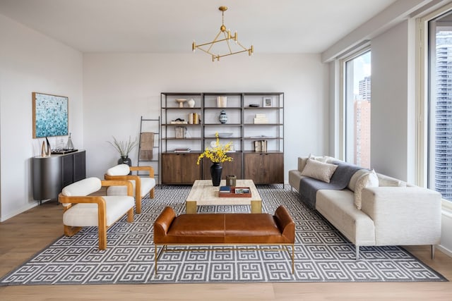 living area featuring a chandelier, wood finished floors, and baseboards