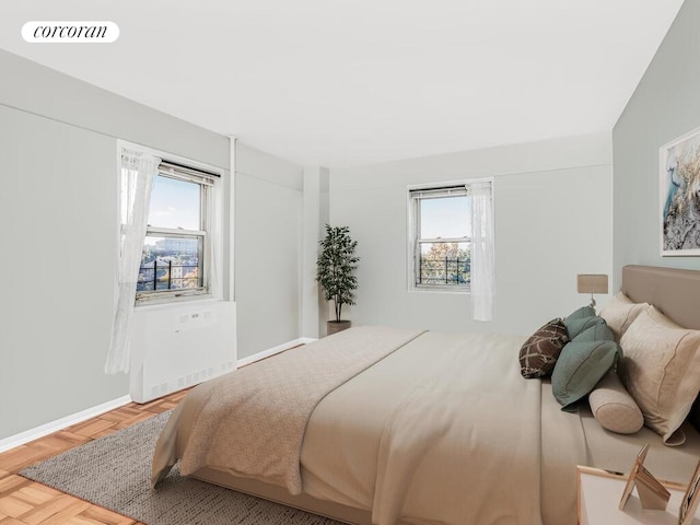 bedroom featuring wood finished floors, baseboards, multiple windows, and visible vents