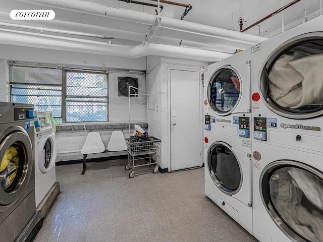 community laundry room featuring tile patterned floors, washer and dryer, and stacked washing maching and dryer