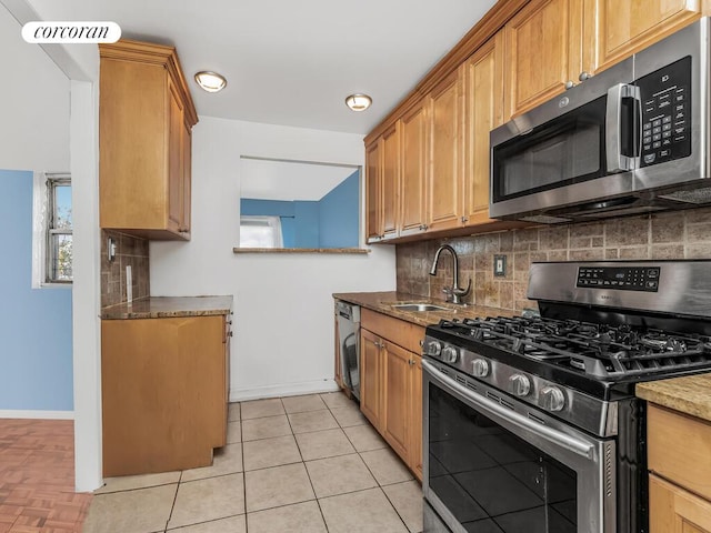 kitchen featuring visible vents, appliances with stainless steel finishes, a sink, decorative backsplash, and baseboards