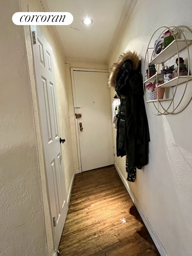 304 E 73rd St Unit 5E, New York City, NY 10021 - hall featuring wood finished floors, crown molding, baseboards, and a textured wall