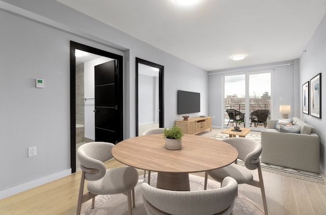 dining space with baseboards and light wood-style floors