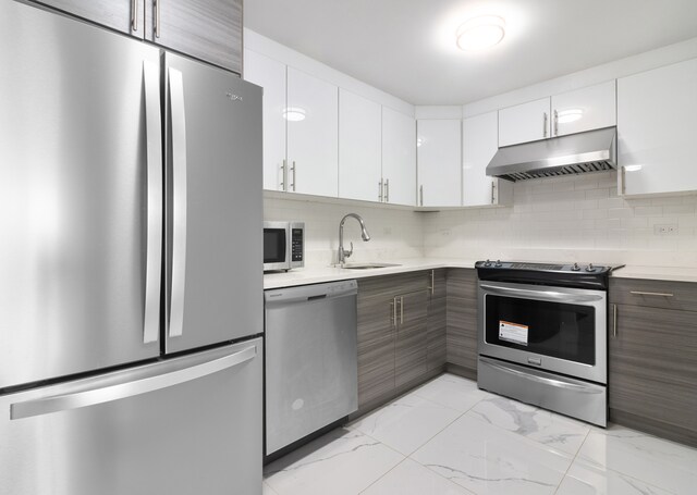 70-09 45th Ave Unit 6D, New York City, NY 11377 - kitchen with appliances with stainless steel finishes, under cabinet range hood, a sink, and light countertops