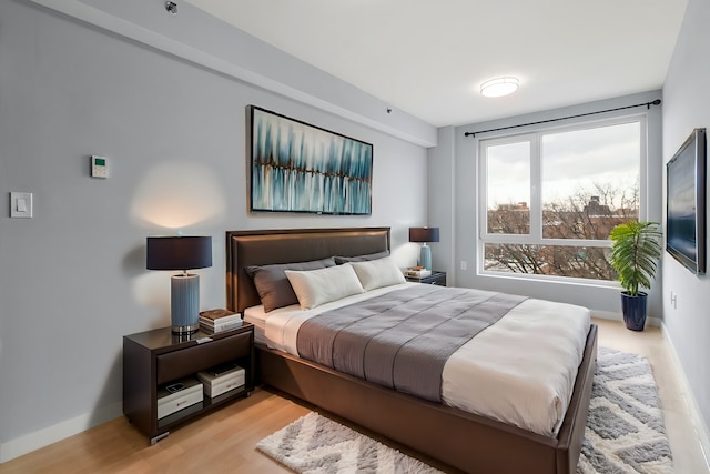 bedroom with light wood-style floors and baseboards