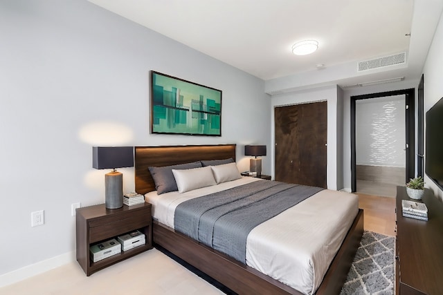 bedroom featuring baseboards, a closet, visible vents, and light wood-style flooring