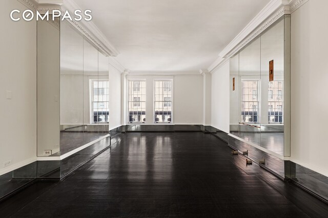 45 E 66th St Unit 4Nw, New York City, NY 10065 - empty room with ornamental molding, dark wood-style floors, and baseboards