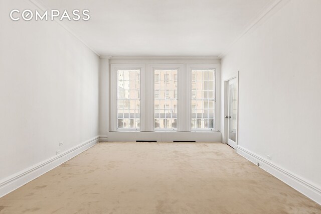 45 E 66th St Unit 4Nw, New York City, NY 10065 - unfurnished room with crown molding, baseboards, and carpet floors