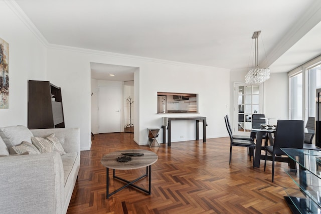 living area featuring a chandelier, ornamental molding, and baseboards