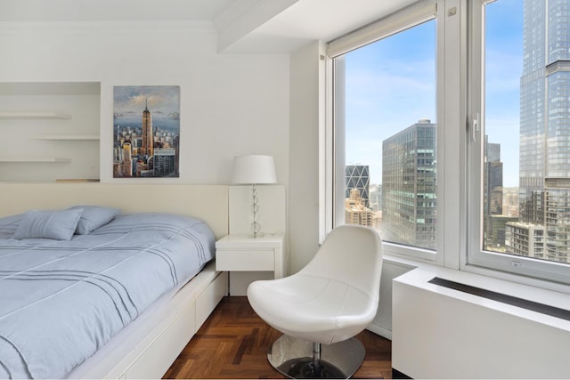 bedroom with a city view, multiple windows, and ornamental molding