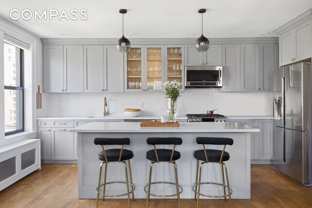 175 W 93rd St Unit 10C, New York City, NY 10025 - kitchen with appliances with stainless steel finishes, radiator, a sink, light countertops, and a center island