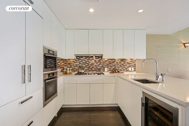 425 W 53rd St Unit 412, New York City, NY 10019 - kitchen featuring a peninsula, beverage cooler, light countertops, a sink, and backsplash