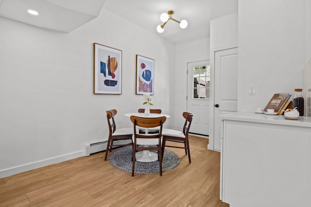 dining area featuring light wood-style floors, baseboards, and a baseboard radiator