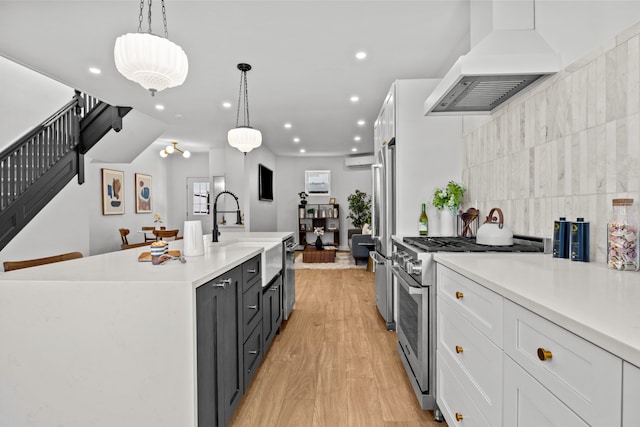 kitchen with recessed lighting, a wall mounted AC, custom range hood, a sink, and premium appliances