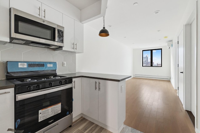 800 5th Ave Unit 2A, New York City, NY 11232 - kitchen with range with gas cooktop, stainless steel microwave, dark countertops, and a peninsula