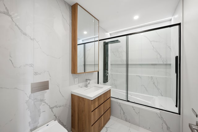 full bathroom with marble finish floors, bath / shower combo with glass door, vanity, and toilet