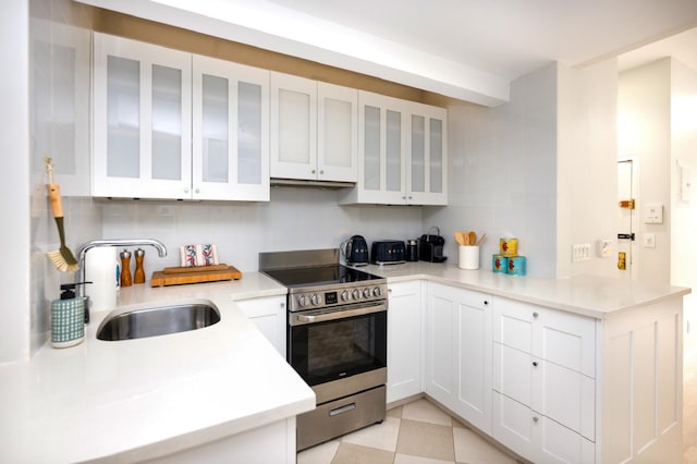 328 W 17th St Unit 5E, New York City, NY 10011 - kitchen featuring stainless steel electric range, a sink, tasteful backsplash, white cabinets, and light countertops