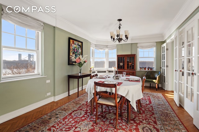 dining space featuring crown molding, baseboards, a notable chandelier, and radiator