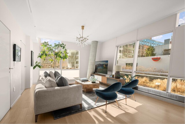 245 10th Ave Unit 3W, New York City, NY 10001 - living room featuring a chandelier and wood finished floors