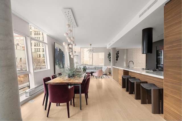245 10th Ave Unit 3W, New York City, NY 10001 - dining room with light wood-style floors and a chandelier