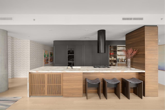 245 10th Ave Unit 3W, New York City, NY 10001 - indoor wet bar featuring wallpapered walls, light wood-type flooring, and gas stovetop
