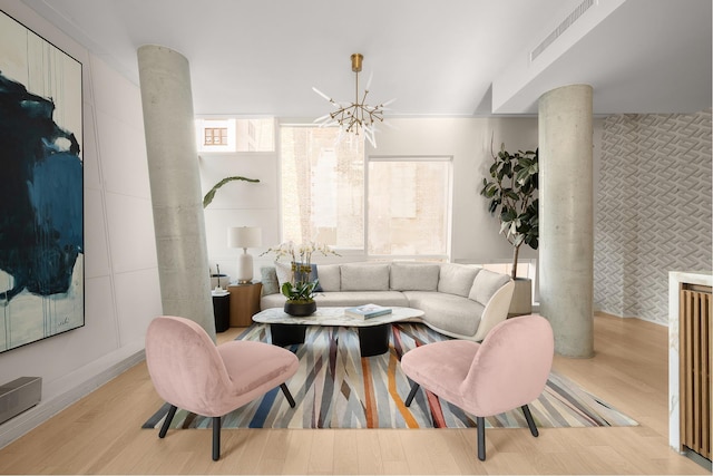 245 10th Ave Unit 3W, New York City, NY 10001 - living room with decorative columns, wood finished floors, and a chandelier