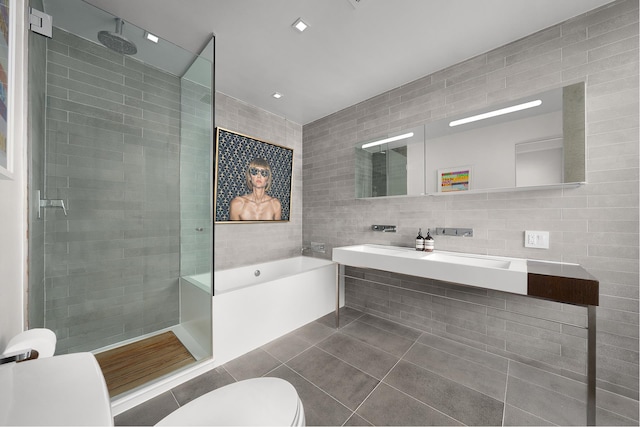 245 10th Ave Unit 3W, New York City, NY 10001 - bathroom with tile walls, toilet, walk in shower, a bath, and tile patterned flooring