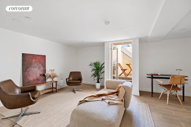 living area with light wood-style flooring, baseboards, and recessed lighting