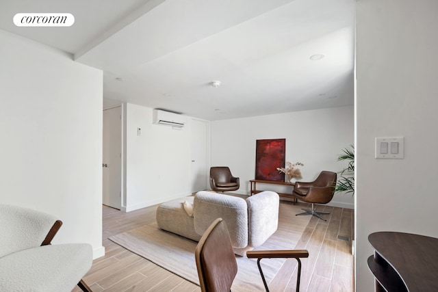 living room featuring an AC wall unit, wood finished floors, and baseboards